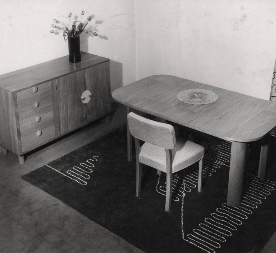 Sideboard adjacent to a dining table and single chair on a rug